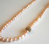 Pink freshwater pearl necklace with gold Swarovski bead accent.